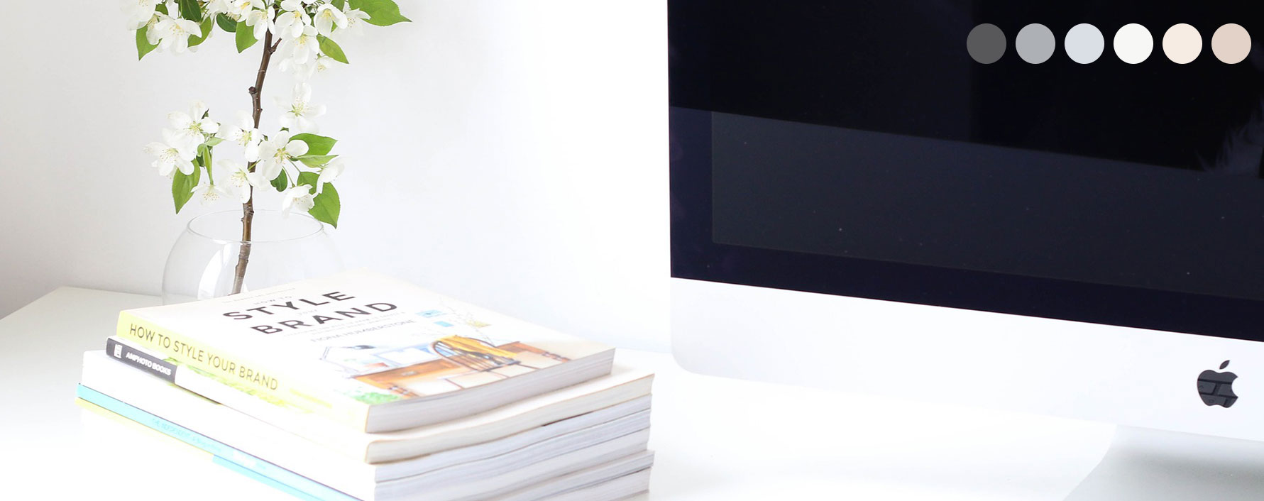 A tablet sits on a table on top of an open brochure. A cup of coffee is on the table beside it.
