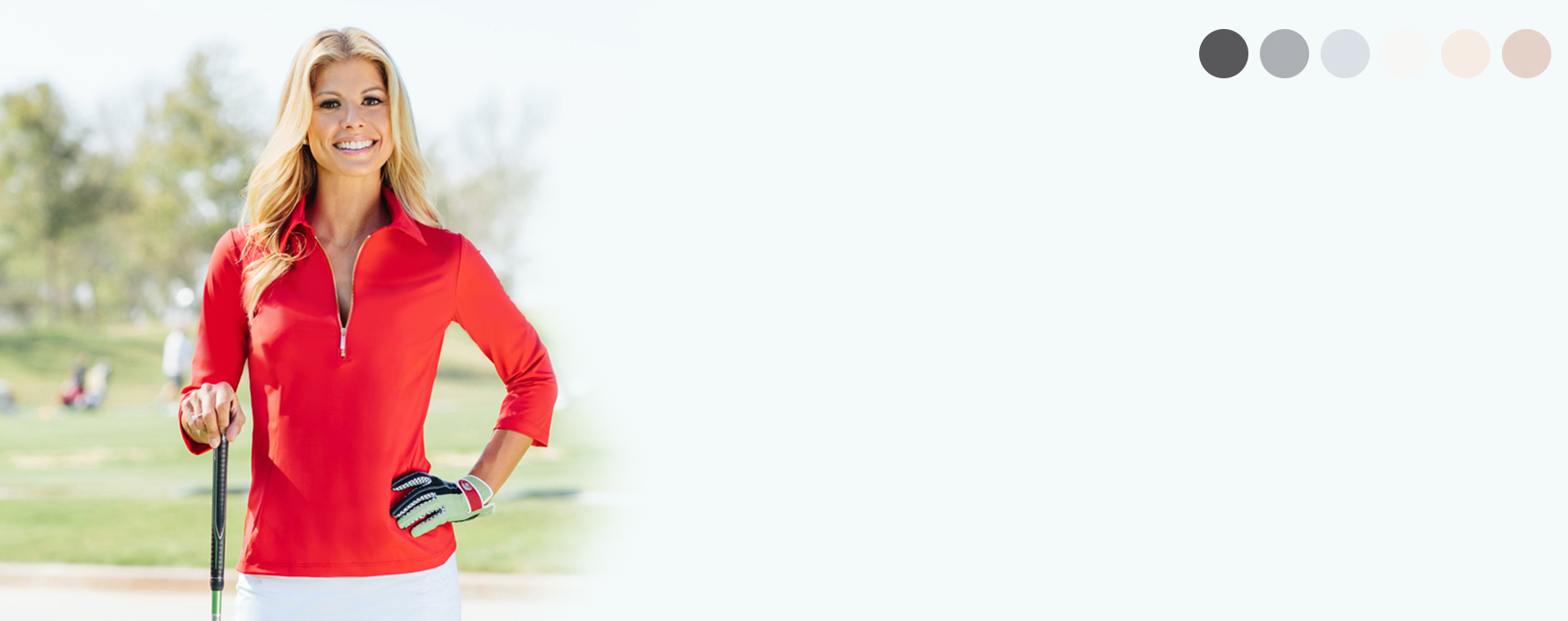 Smiling blond woman in a red collared shirt standing on golf course.